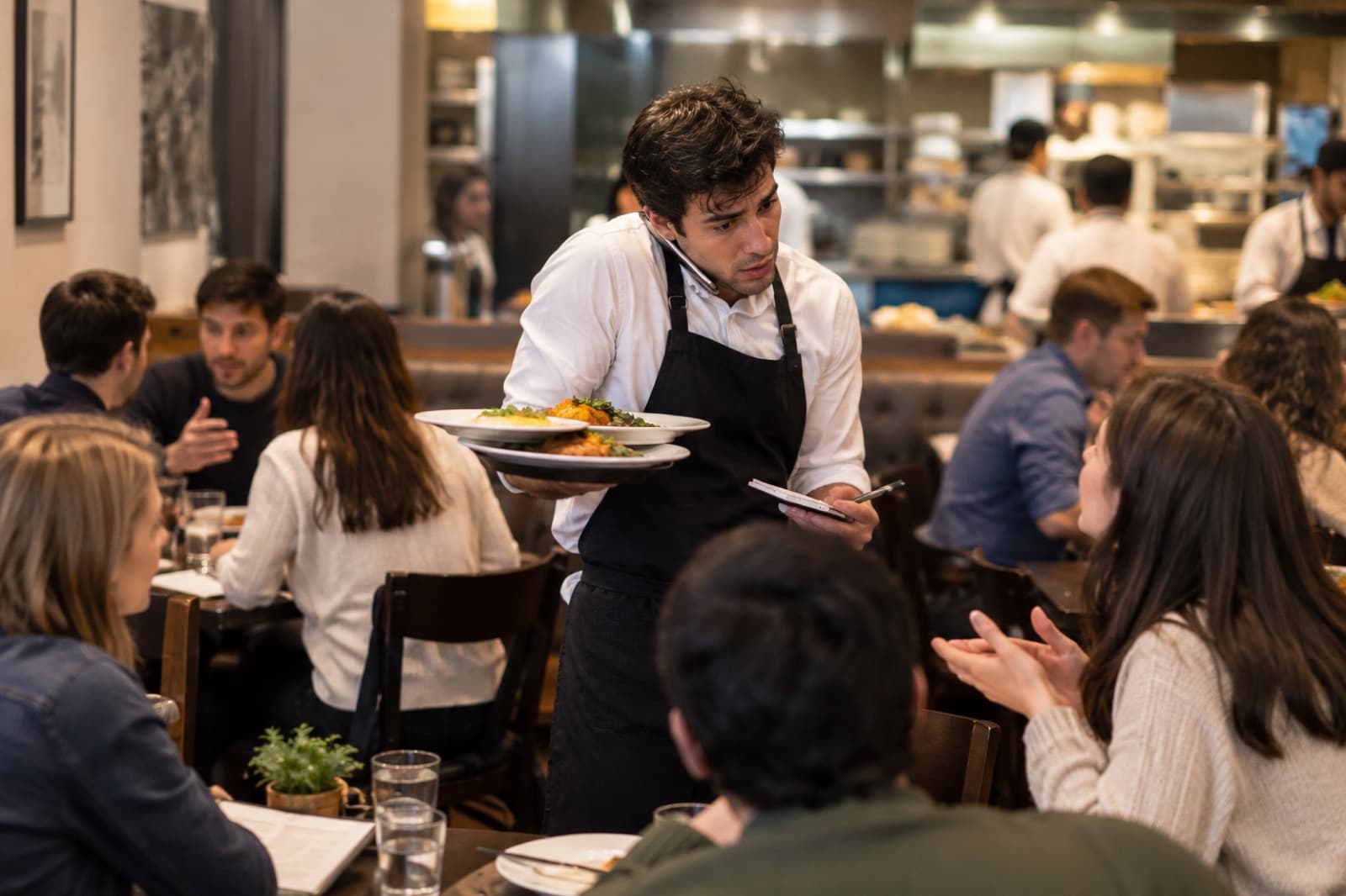Photo of a waiter handling several tables at once during rush hour.